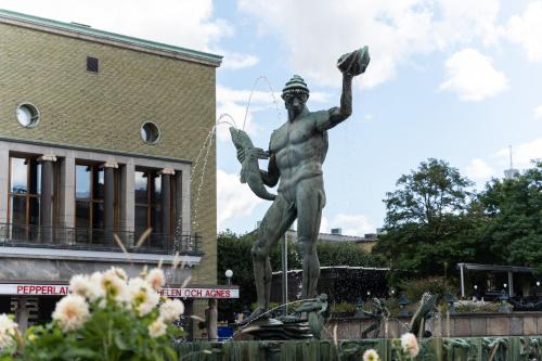 a statue in front of a building with a statue of a man at Live and Stay Ekmanska in Gothenburg