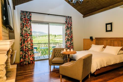 a bedroom with a bed and a chair and a window at Le Palais des Cerisiers in Azrou