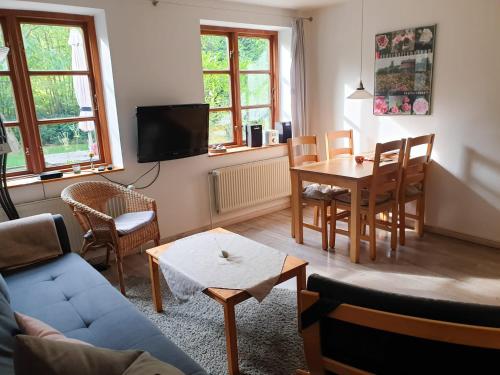 ein Wohnzimmer mit einem Sofa, einem Tisch und Stühlen in der Unterkunft Ferienwohnung Hyggebo in Langballig