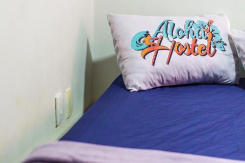a bed with a pillow that says alanta hotel at Aloha Hostel Pinhões in Fortaleza