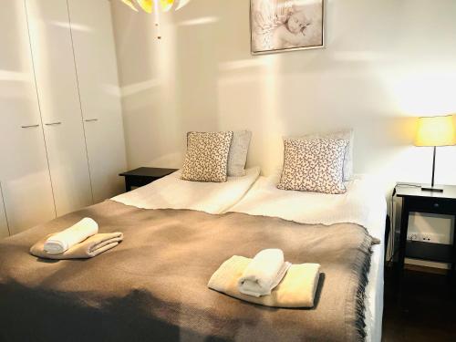a bedroom with a bed with two towels on it at Galaxy Apartments Airport in Vantaa