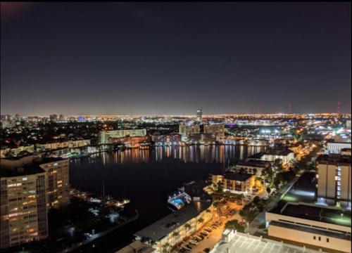 a view of a city at night with the water at Relaxing BeachWalk Getaway Studio for 4 Guests 405B in Hallandale Beach
