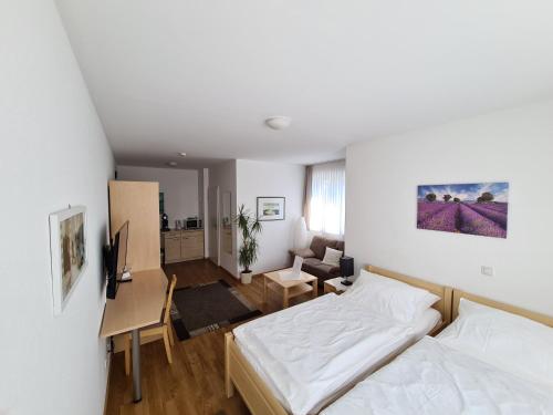 1 dormitorio con cama, escritorio y sala de estar. en Hotel Am Wintergarten en Bocholt