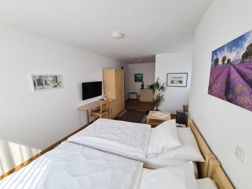 a bedroom with a bed and a desk at Hotel Am Wintergarten in Bocholt