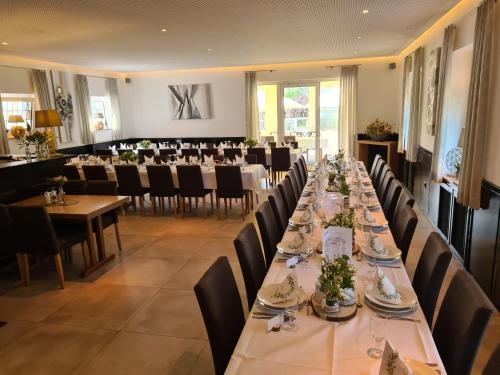 a long dining room with tables and chairs at Hotel Am Wintergarten in Bocholt