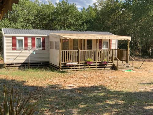 a small house with a porch and a deck at Domaine de Labelo in Commensacq