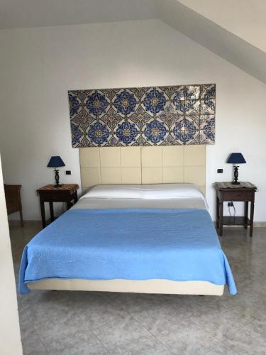 Un dormitorio con una cama grande con una manta azul. en Maison de Charme Iommella, en Sant'Agnello