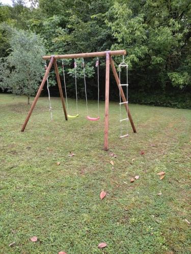 an empty swing set in a grassy field at Superb contemporary 2 bed villa +private pool in Cancon
