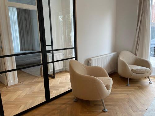 a living room with two chairs and a mirror at Canal House in Historic City Center Gouda in Gouda