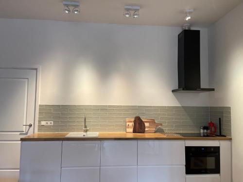 a kitchen with white cabinets and a sink at Canal House in Historic City Center Gouda in Gouda