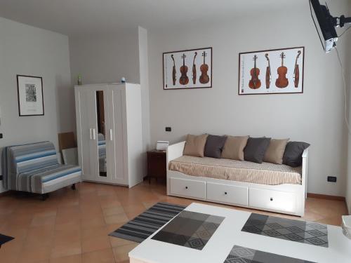 a living room with a couch and a chair at La strada del liutaio nel cuore di Cremona in Cremona