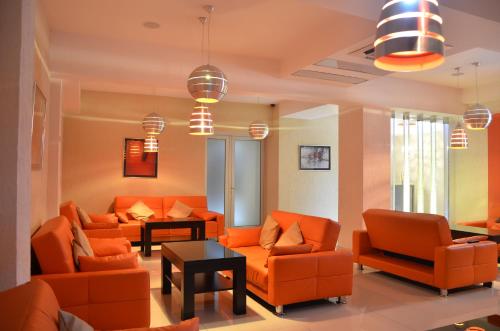 a living room with orange couches and chairs at Hotel Orion Tbilisi in Tbilisi City