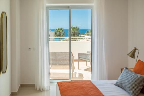 een slaapkamer met een bed en uitzicht op de oceaan bij Orange Beach Ocean View - Porto de Mos in Lagos