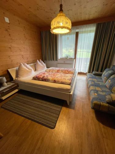 a bedroom with a large bed and a chandelier at Appartment Sonnenschein in Uttendorf