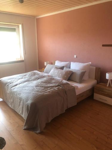a bedroom with a large bed with white pillows at Ferienwohnung Klosterblick in Bastheim