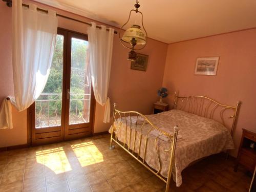 a bedroom with a bed and a large window at Seaview Garden Villa in LʼÎle-Rousse