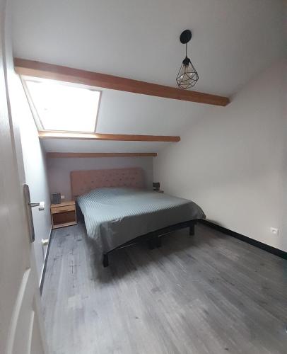 une chambre mansardée avec un lit et une fenêtre dans l'établissement Galta des Matrus Appartement cosy 8kms de l Océan, à Grues