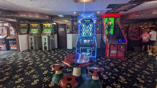 uma sala de jogos com um sistema de jogos de vídeo e máquinas em Gloria Stay - Aberystwyth Caravan em Aberystwyth