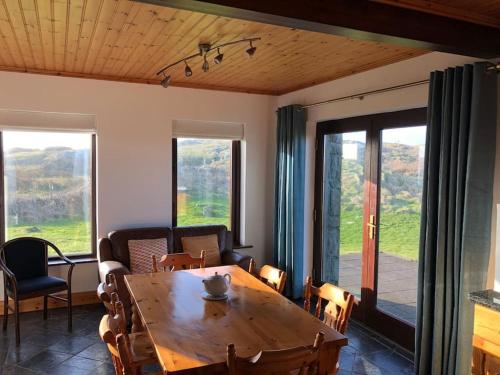 a living room with a wooden table and chairs at Luxury Sea View Cottage Ballyconneely Winter Specials in Ballyconneely