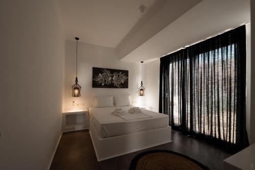 um quarto com uma cama branca e uma grande janela em Villa Unica - Mikri Vigla, Seaview, Pool & Jacuzzi em Mikri Vigla