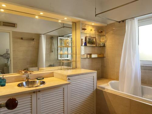 a bathroom with a sink and a tub and a mirror at Casa das Boganvilias - Moradia com jardim in Lisbon