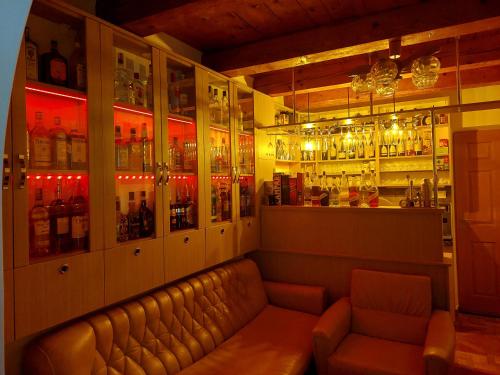 a bar with a couch and many bottles of alcohol at DOBRA RAKIJA - transit sleep in Dobra