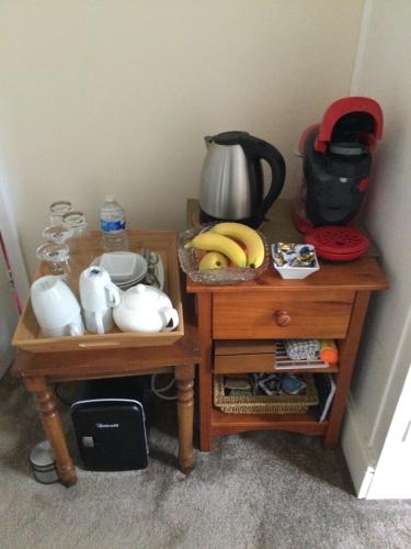 two wooden tables with a tea pot and bananas on them at Endearing Edwardian House in Quaint Deal, Kent in Deal