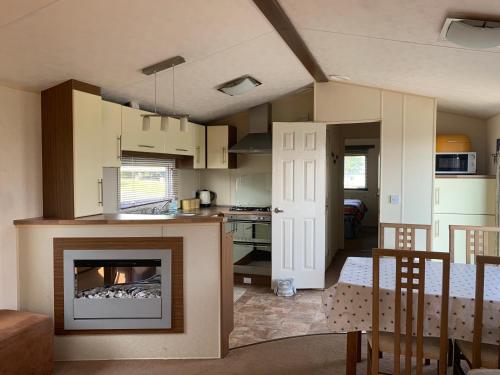 een keuken en een woonkamer met een open haard bij Thornwick Bay Haven Site-Large Homely Static Caravan, Sun, Sea And Sand (SEA VEIWS , LIGHTHOUSE VEIWS) in Flamborough
