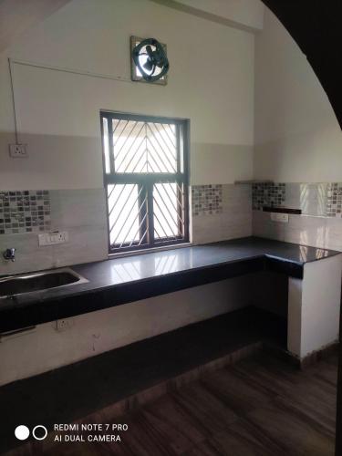an empty kitchen with a sink and a window at Yog Bhawan in Greater Noida