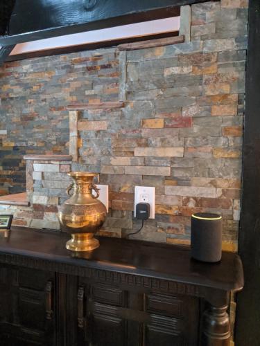a stone wall behind a table with a vase on it at Breckenridge Chalet near Yosemite. Dog friendly! in Groveland