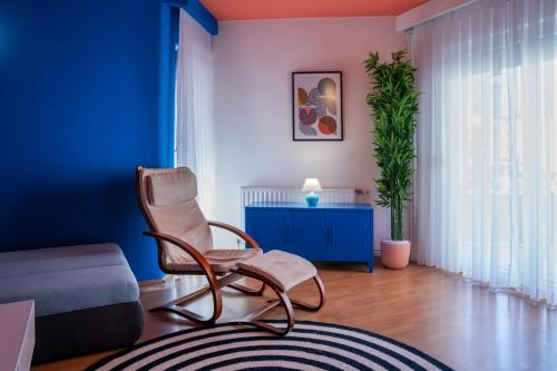 a living room with a chair and a blue wall at Artament Prishtina in Pristina