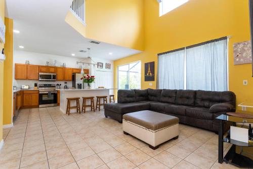 a living room with a couch and a kitchen at 7 Bedroom Mansion Near Disney in Kissimmee