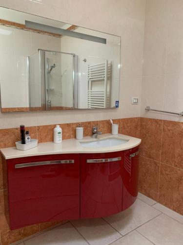 baño con lavabo rojo y espejo en Toto House, en Mesagne