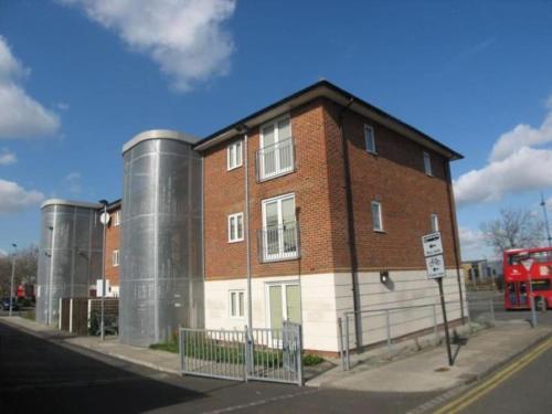 a brick building on a street with a double decker bus at Comfy 2 bed Flat with free Parking, close to Tube in Woolwich