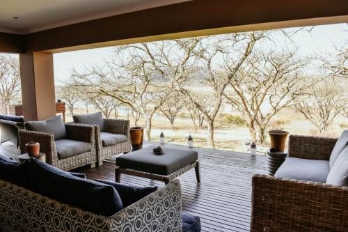 a porch with couches and chairs and a large window at Cwebile Guesthouse in Winterton