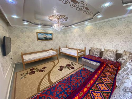 a bedroom with two beds and a chandelier at Naryn Guest House in Naryn