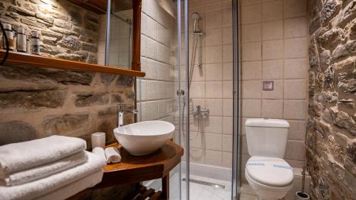 a bathroom with a toilet and a glass shower at Guesthouse Laoula in Gerolimenas