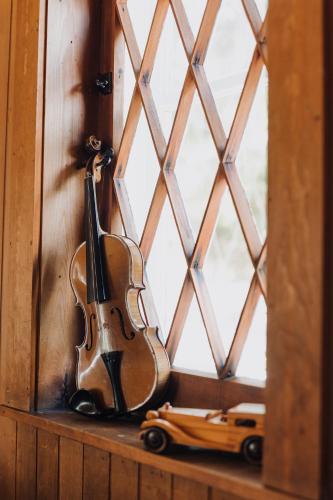 a violin sitting on a window sill next to a toy car at Auberge Les Sources in La Malbaie