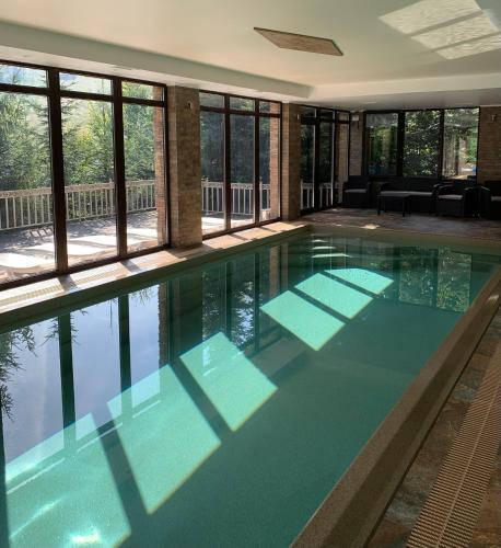 a swimming pool in a building with windows at Idylia Grand Villas in Migovo