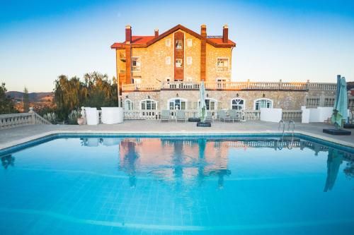une grande piscine en face d'un grand bâtiment dans l'établissement Le Palais des Cerisiers, à Azrou