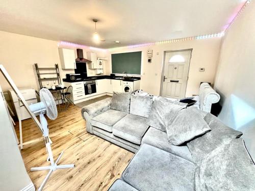 a living room with a couch and a kitchen at Lt Properties Luton town centre studio Tv Netflix Ground Floor 2 in Luton