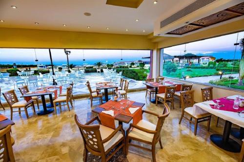 a restaurant with tables and chairs and a view of the ocean at Gravity Hotel & Aqua Park Hurghada Families and Couples Only in Hurghada