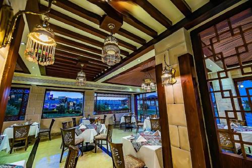 a restaurant with tables and chairs and windows at Gravity Hotel & Aqua Park Hurghada Families and Couples Only in Hurghada