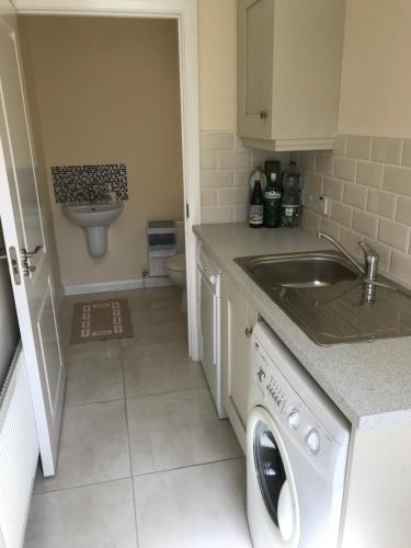 a small kitchen with a sink and a washing machine at Modern 3-bedroom townhouse in the Mournes in Newry