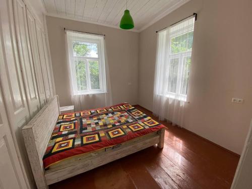 een slaapkamer met een bed in een kamer met 2 ramen bij Authentic house with a huge garden in Utsera