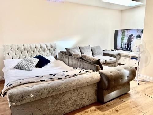 a living room with a bed and a couch at Lt Properties Luton town centre studio Tv Netflix Ground Floor 2 in Luton