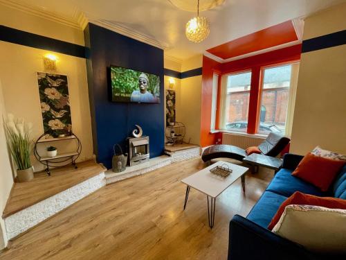 a living room with a couch and a tv on a wall at Kimberworth 4 Bedrooms House 8 Beds Close to M1 Suitable For Longer Stay in Rotherham
