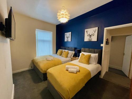 two beds in a room with blue walls at Kimberworth 4 Bedrooms House 8 Beds Close to M1 Suitable For Longer Stay in Rotherham