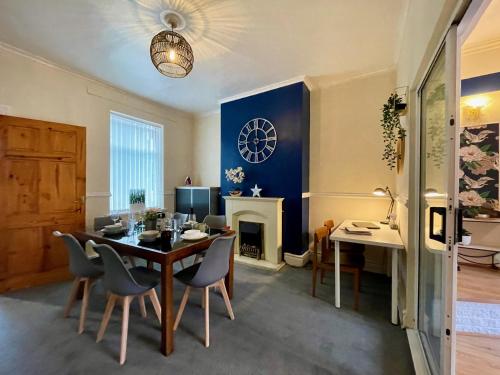 a dining room with a table and chairs and a fireplace at Kimberworth 4 Bedrooms House 8 Beds Close to M1 Suitable For Longer Stay in Rotherham