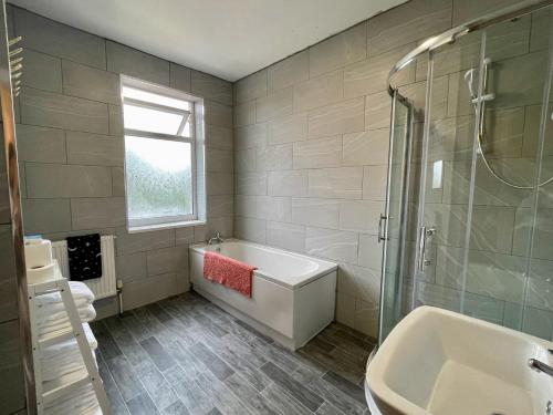 a bathroom with a tub and a sink and a shower at Kimberworth House, 4 Bedrooms, WIFI, Close to M1, Longer Stay, Free Parking in Rotherham